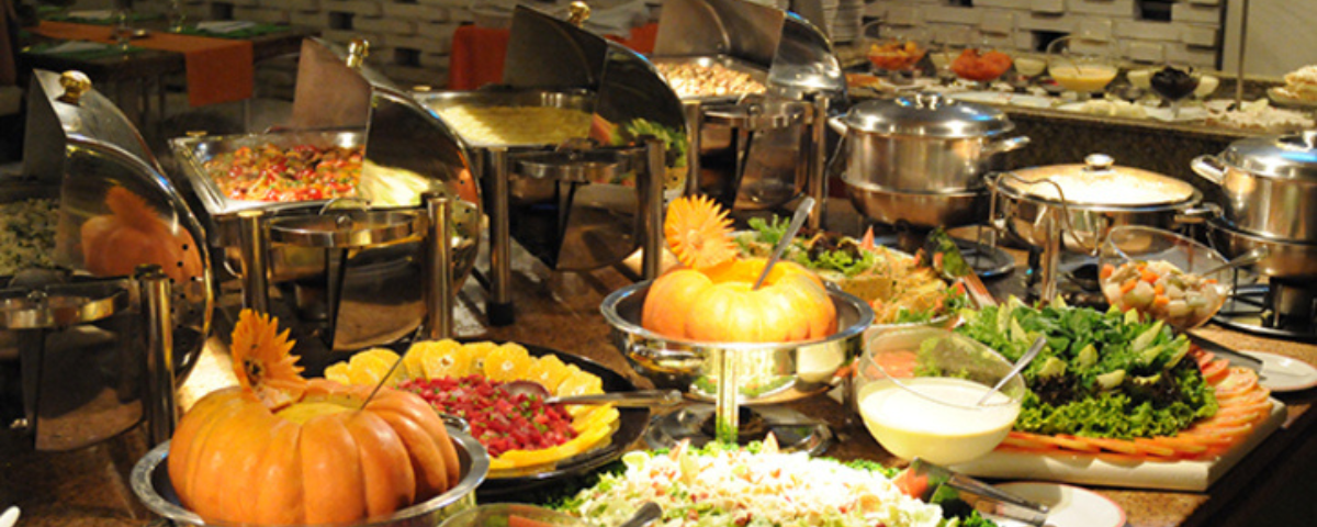 Buffet de restaurante com diversos pratos à disposição.