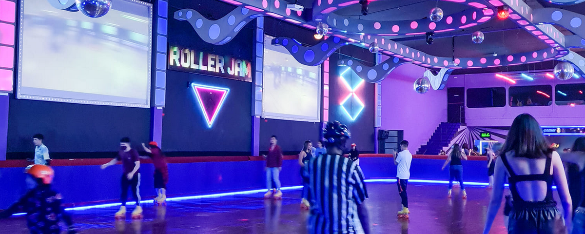 Espaço interno do Roller Jam, com diversas pessoas patinando no ambiente. 