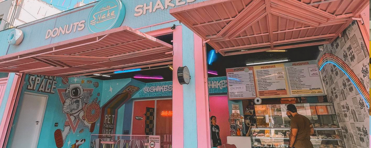 Fachada da Shake Shake Milkshakes, uma das docerias em São Paulo, com tons de azul claro e rosa. 