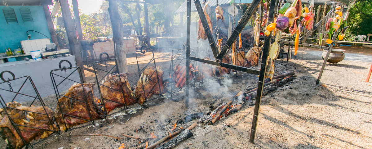 Carnes sendo feitas na brasa, ao ar livre, no restaurante Costelão Fogo de Chão.
