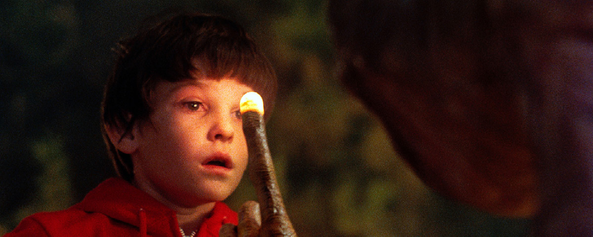 Personagem ET com o dedo iluminado no rosto do menino do filme. Uma cena clássica.