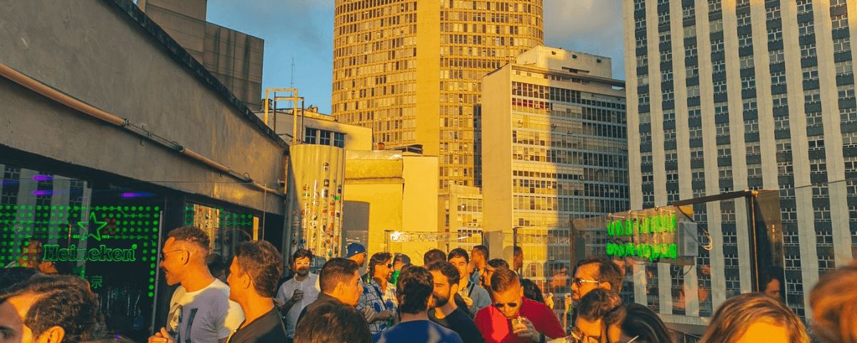 Foto da Tokyo, um dos lugares para comemorar o aniversário em SP, com pessoas conversando e dançando no terraço da balada.
