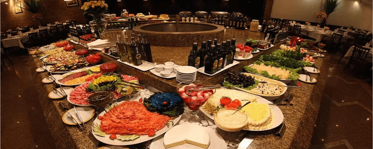 Foto do self-service da Boizão Grill, com diversos alimentos, como saladas e frutas. 