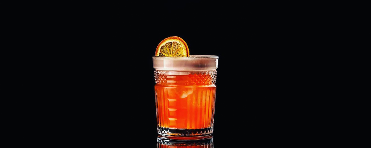 Drink laranja em um fundo preto do Due Bar Bistrô.