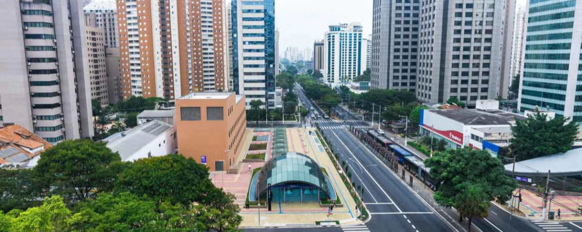 Foto tirada de cima do bairro Moema, com diversos prédios ao redor e uma avenida ao centro da imagem.