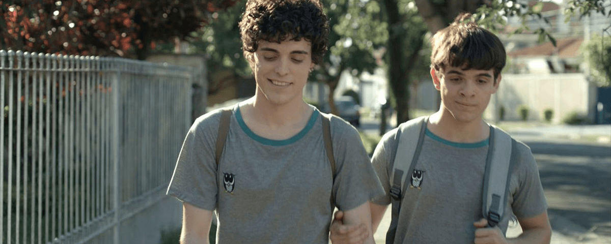 Cena de Hoje Eu Quero Voltar Sozinho, um dos filmes brasileiros para assistir. Na imagem, estão os dois protagonistas usando o uniforme cinza do colégio.