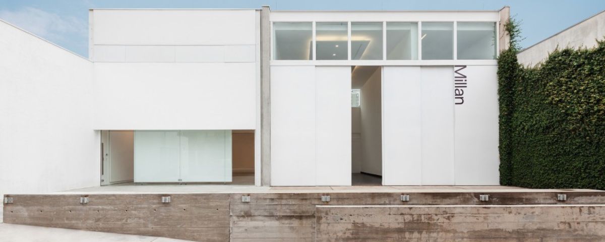 A Galeria Millan fica no Bairro de Pinheiros e tem a estética "clean" em uma casa retangular toda branca, com algumas janelas de vidro na parte superior. 