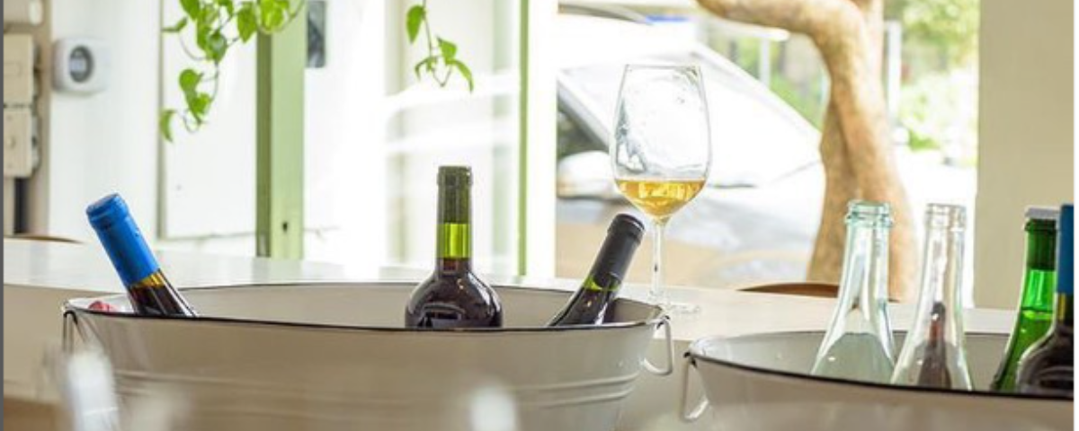 Garrafas de vinho e um taça no Clos Wine Bar e Bistrô. Tomar um vinho é uma ótima maneira de aproveitar as temperaturas mais baixas. 