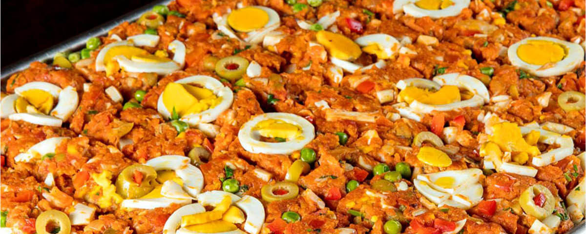 Tabuleiro de cuscuz paulista com ovos, azeitonas, ervilha, e outros ingredientes é servido no restaurante O Compadre. 