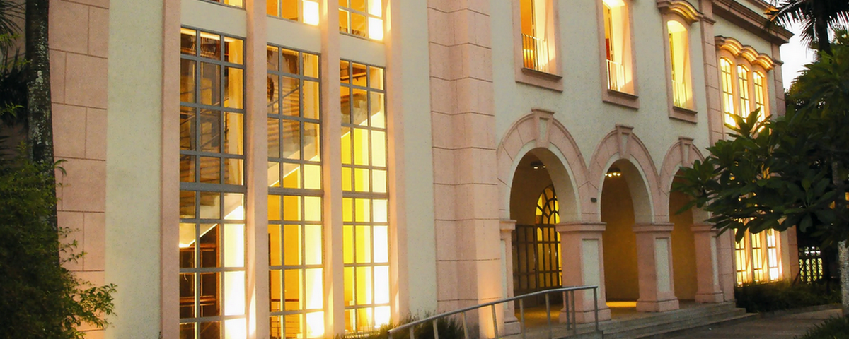 A entrada no teatro TUCA, na região de Perdizes, possui arcos e grandes janelas, com uma mistura das cores rosa e branca. 