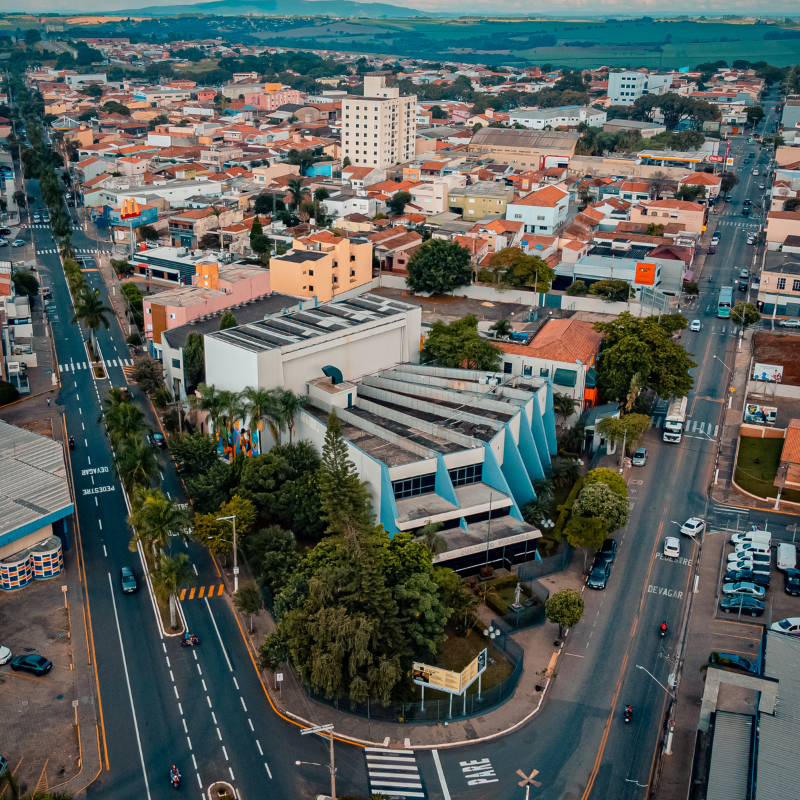 Um pedaço da cidade de Tatuí vista de cima, com duas ruas cruzando e diversas casas espalhadas. Na ponta, entre as duas ruas, está o Conservatório de Tatuí, que tem as cores azul e branco. 