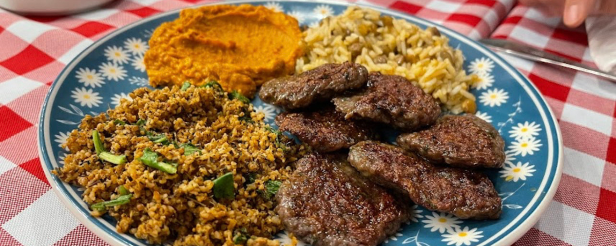 Prato de comida turca em SP, com carne, arroz com lentilha, purê de abóbora e alguns grãos temperados. 