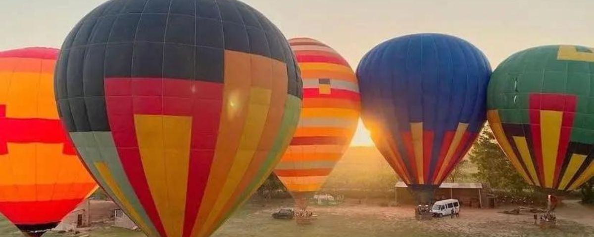 Diversos balões coloridos "estacionados" no chão. Andar de balão é um ótimo passeio para o Dia Mundial do Turismo. 