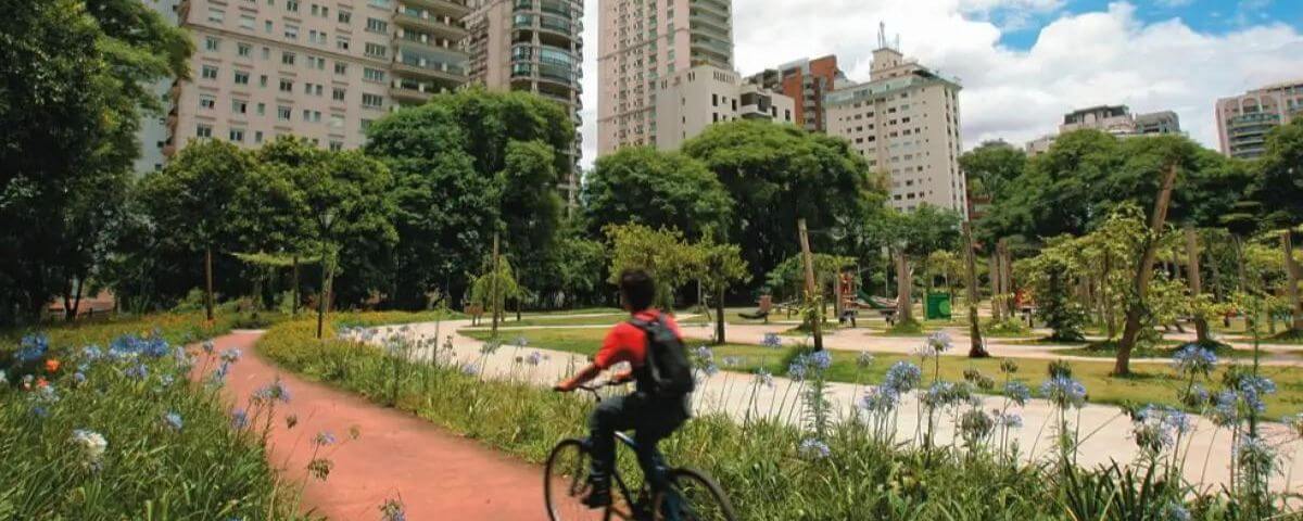 Pessoa com blusa vermelha anda de bicicleta pela ciclovia do Parque do Povo. Uma ótima ideia de passeio para o feriado de 7 de Setembro 2023. 