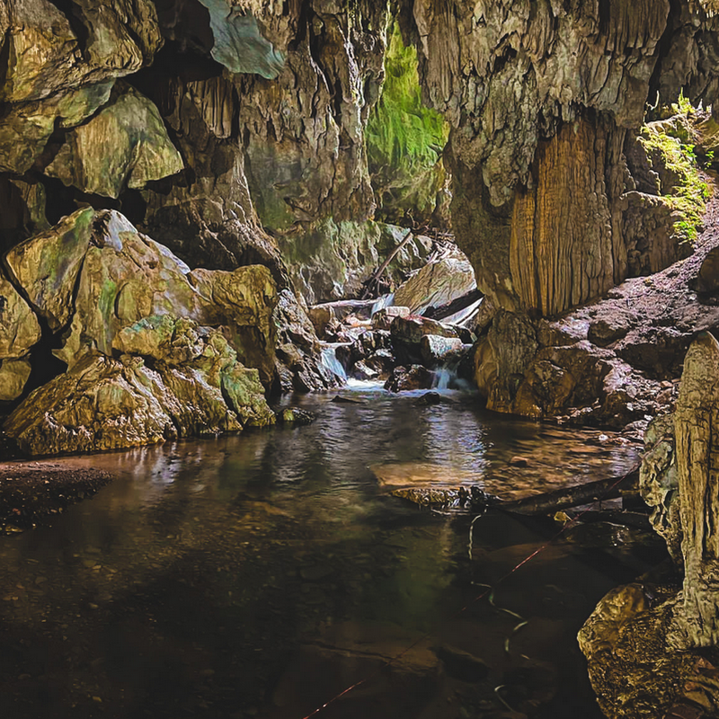 Dentro da Caverna do Morro Preto passa água e há diversas formações rochosas ao redor. 