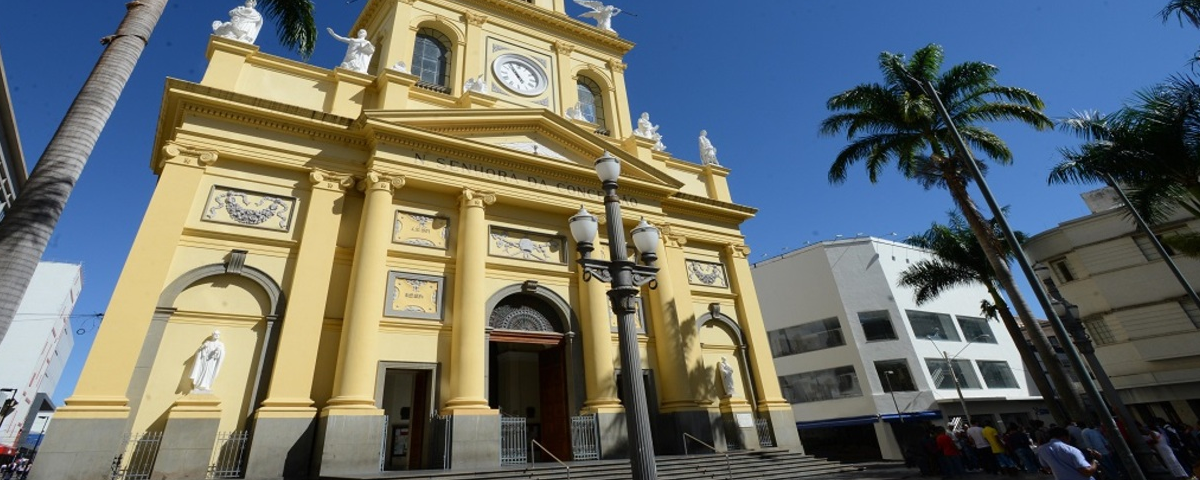 Catedral Metropolitana de Campinas possui a fachada na cor amarelo claro, com um relógio no centro e esculturas ao longo da catedral. 