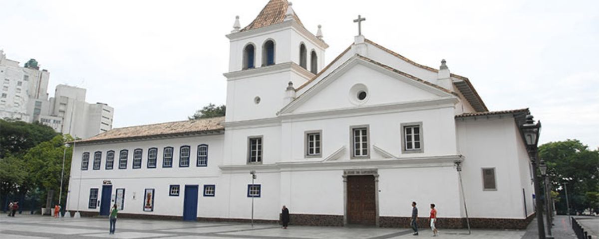 O Pateo do Collegio possui um edifício branco, com uma cruz na parte de cima, como se fosse uma igreja, e na parte esquerda janelas e portas possuem a coloração azul. 