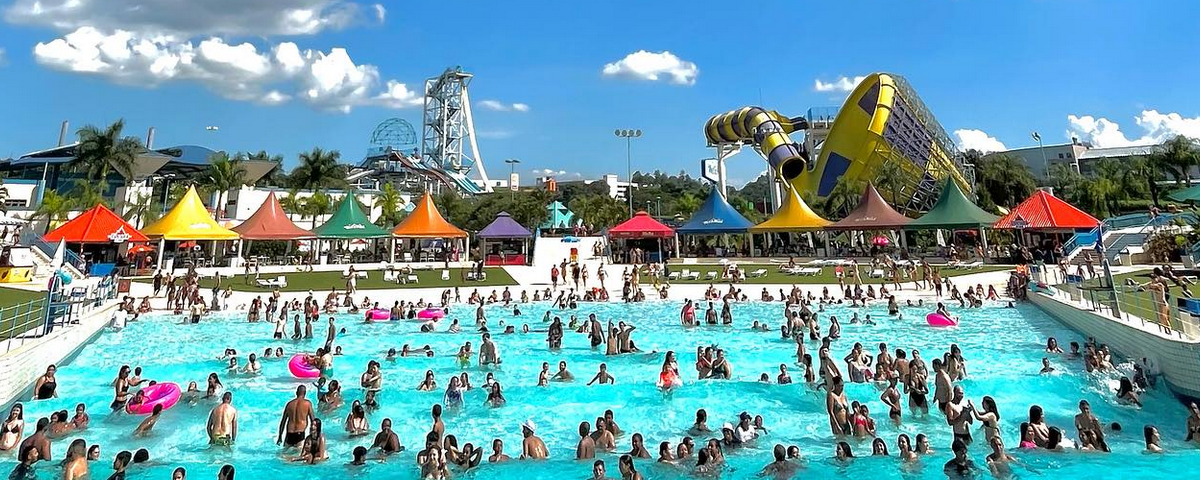 Piscina de ondas cheia de pessoas e brinquedos aquáticos ao fundo. Ir ao Wet' n Wild também é uma ótima ideia neste Dia das Crianças 2023. 