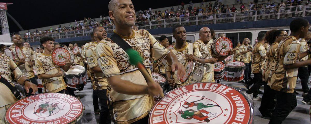 Integrantes da escola de samba Mocidade Alegre tocam instrumentos durante apresentação no sambódromo. 