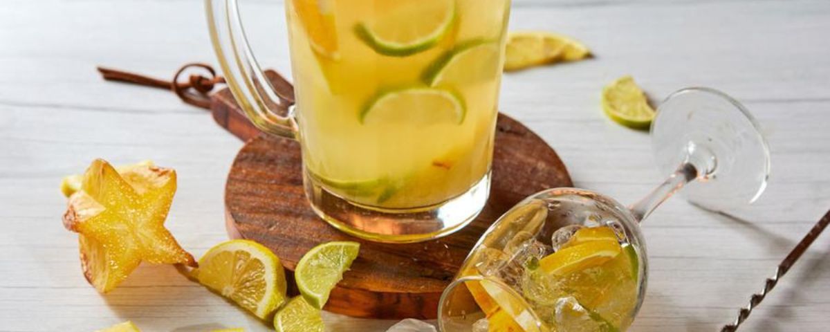 Taça e jarra com suco de limão e laranja. 