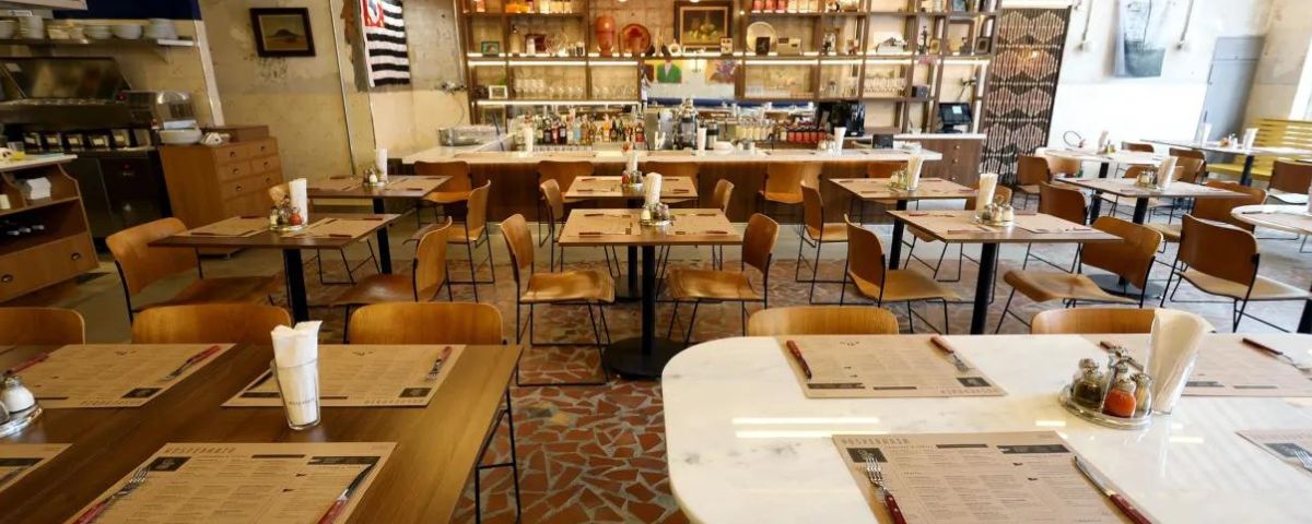 O salão do Hospedaria Restaurante possui varias mesas e cadeiras em tons de marrom e bege. O restaurante também está com opções especiais para o aniversário de SP 470 anos. 