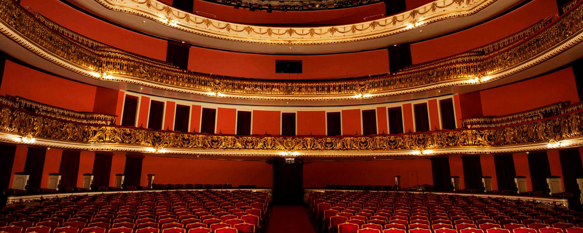 Platéia do Teatro Municipal Arthur Azevedo possui poltronas e decoração nas cores vermelho. 