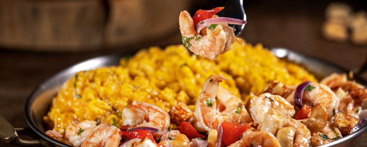 Prato com camarões e risoto de açafrão é servido no Restaurante Camarões, que trabalha com frutos do mar em SP. 