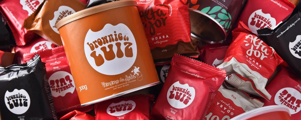 Diversos brownies do Luiz em latas e em pequenos pacotes. 