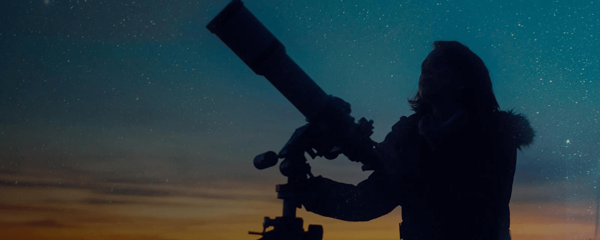 Mulher segurando um telescópio e observando as estrelas. 