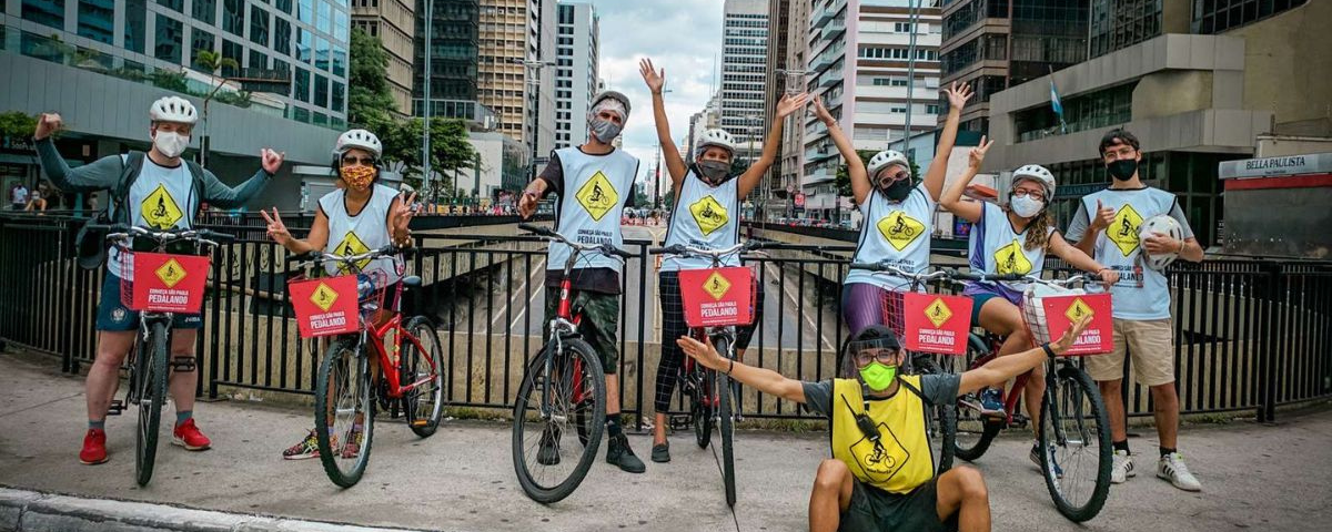 Pessoas posando para foto durante um tour de bike pela Avenida Paulista. 