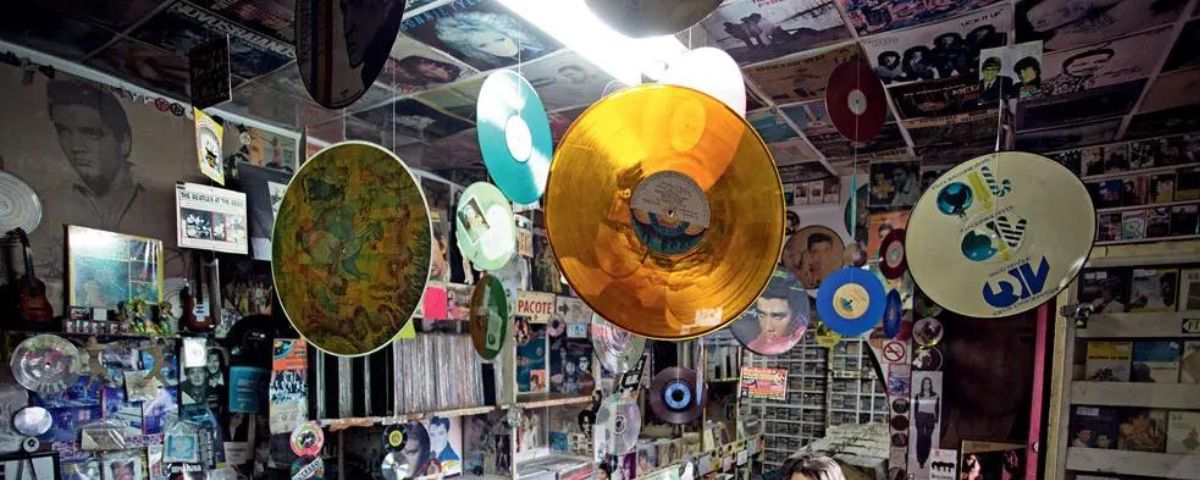 Discos de vinil brilhosos pendurados no teto, decorando uma loja de discos. 