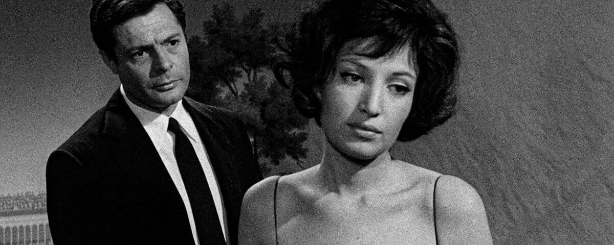 Homem e mulher atuando em filme preto e branco. 