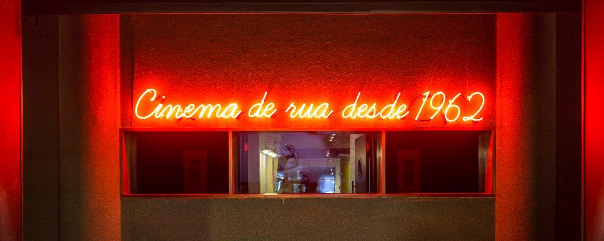 Frase "Cinema de rua desde 1962" escrita em um letreiro vermelho iluminado. 