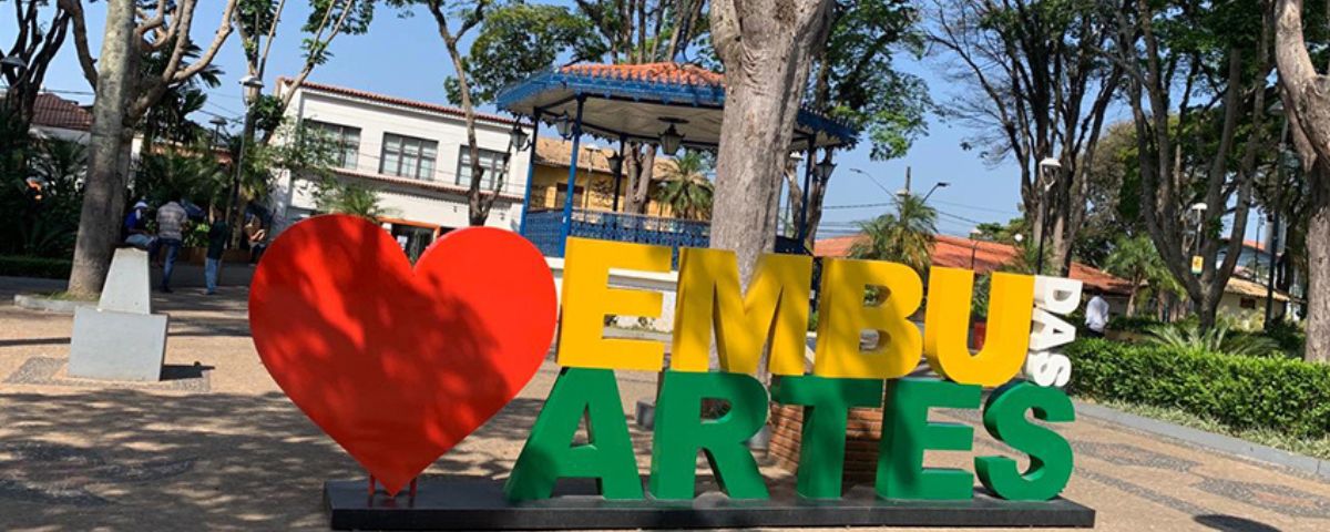 Placa colorida escrito "Eu amo Embu das Artes". Essa é uma das cidades próximas a SP. 