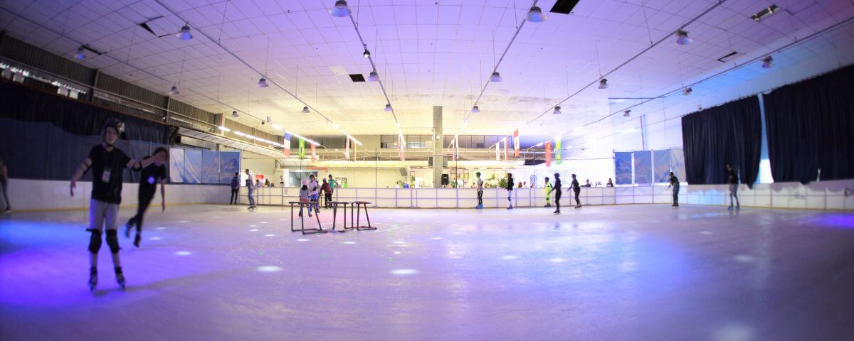 Pessoas praticando patinação no gelo na Arena Ice. 