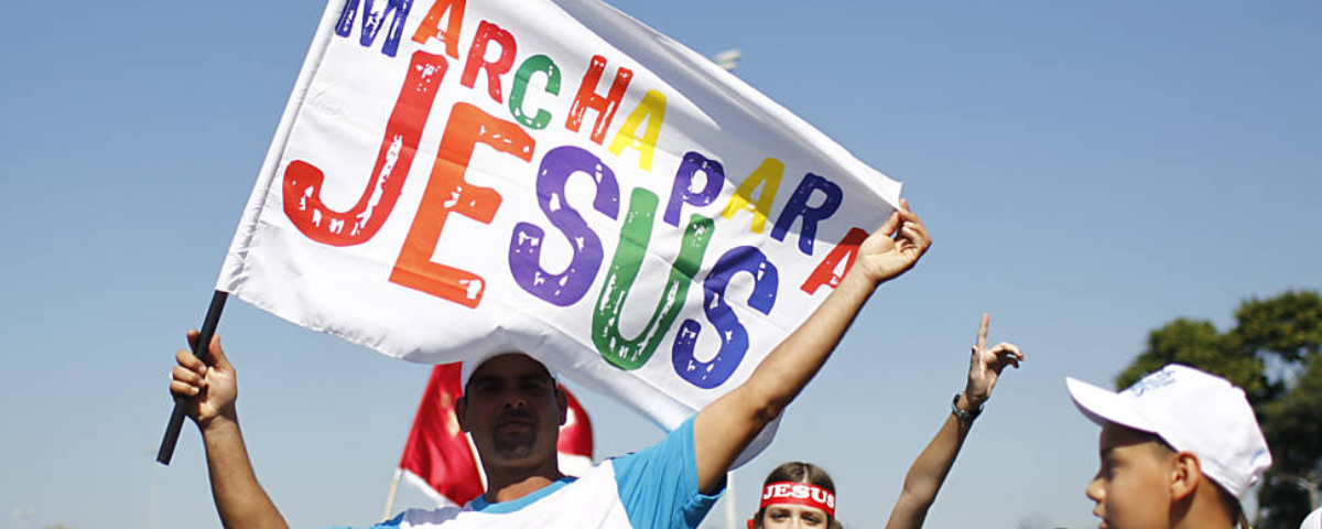 Homem segurando faixa escrito "Marcha para Jesus". O evento vai acontecer no Feriado de Corpus Christi.