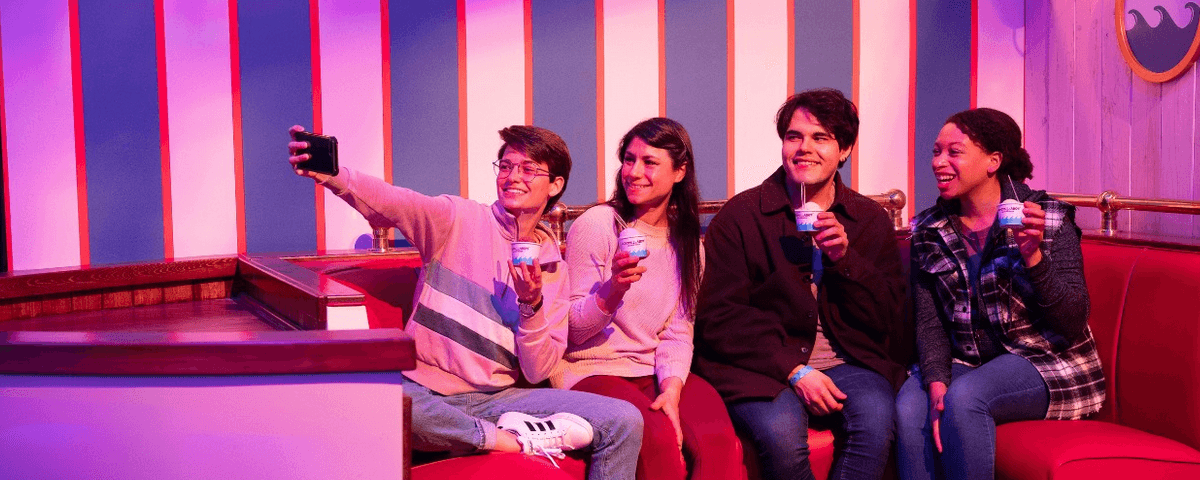 Quatro amigos tirando foto na exposição de Stranger Things. 