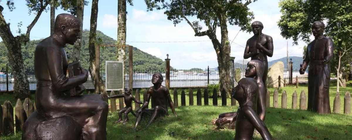 Estátuas de bronze em cima de gramado na cidade de Bertioga. 