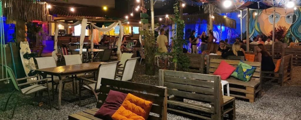 Mesas na área externa da La Casita Bar, um dos passeios em Bertioga. 