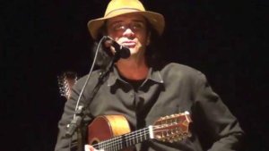 Imagem de Almir Sater com um violão em um show